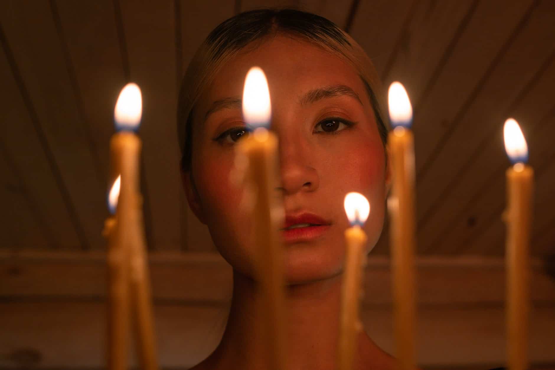 woman with lighted candles on her mouth